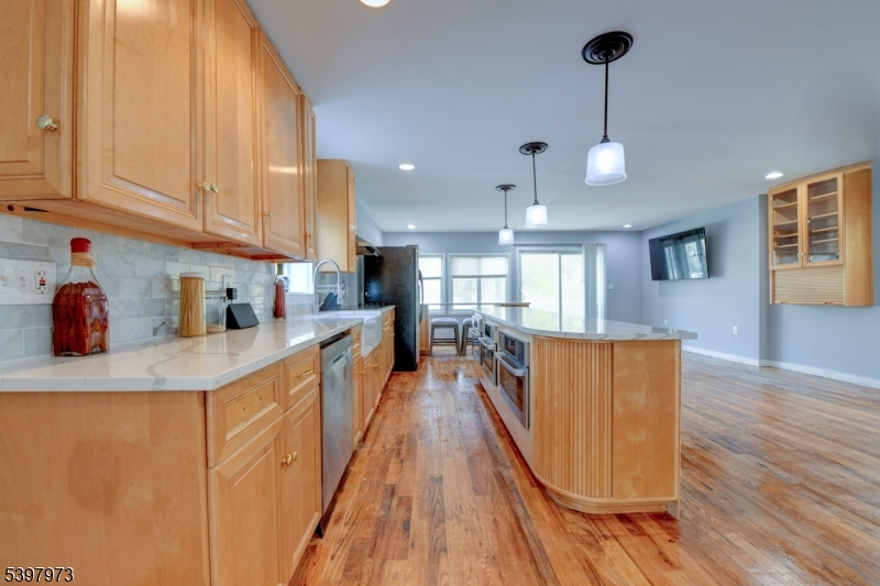 105 Battlehill Avenue Springfield, NJ 07081 - Photo 5 of 22 a large kitchen with stainless steel appliances granite countertop a stove a sink dishwasher and a refrigerator with wooden floor
