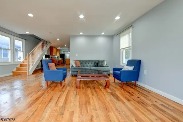 a living room with furniture and a wooden floor