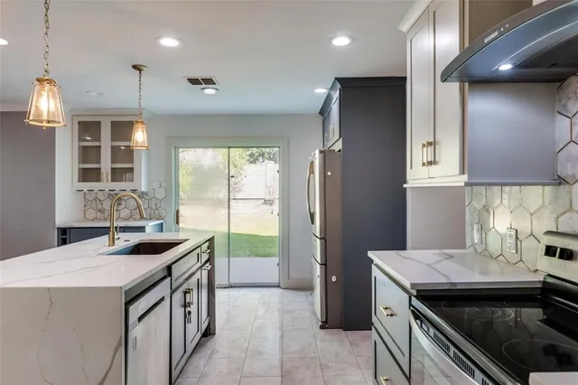 a kitchen that has a sink a stove and a refrigerator