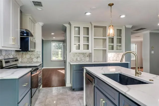 a kitchen with a sink stove and cabinets
