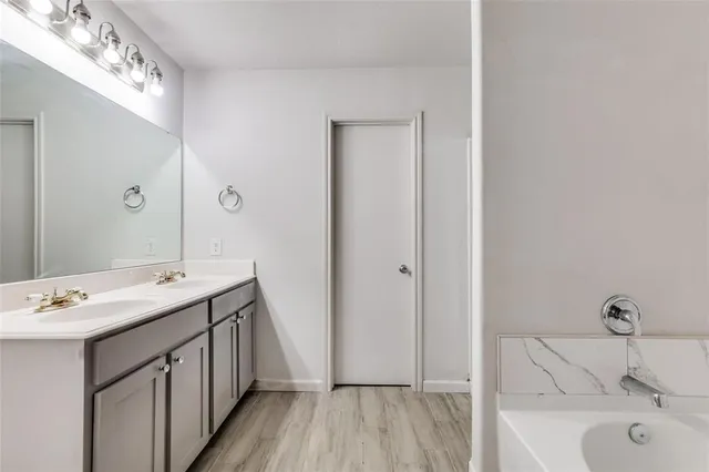 a bathroom with a tub sink and mirror
