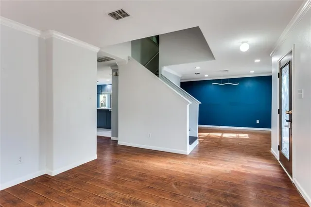 a view of hallway with stairs and wooden floor