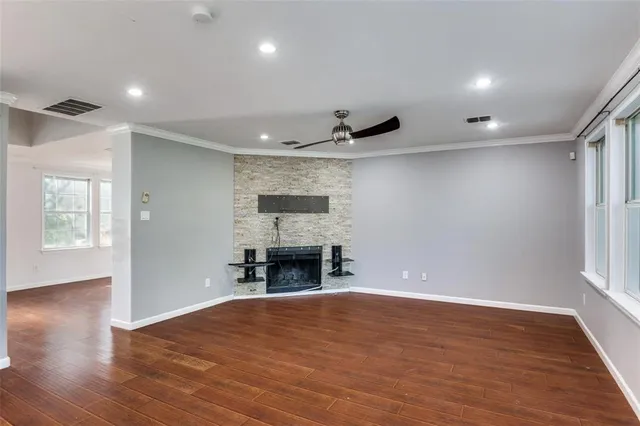 an empty room with wooden floor and fireplace
