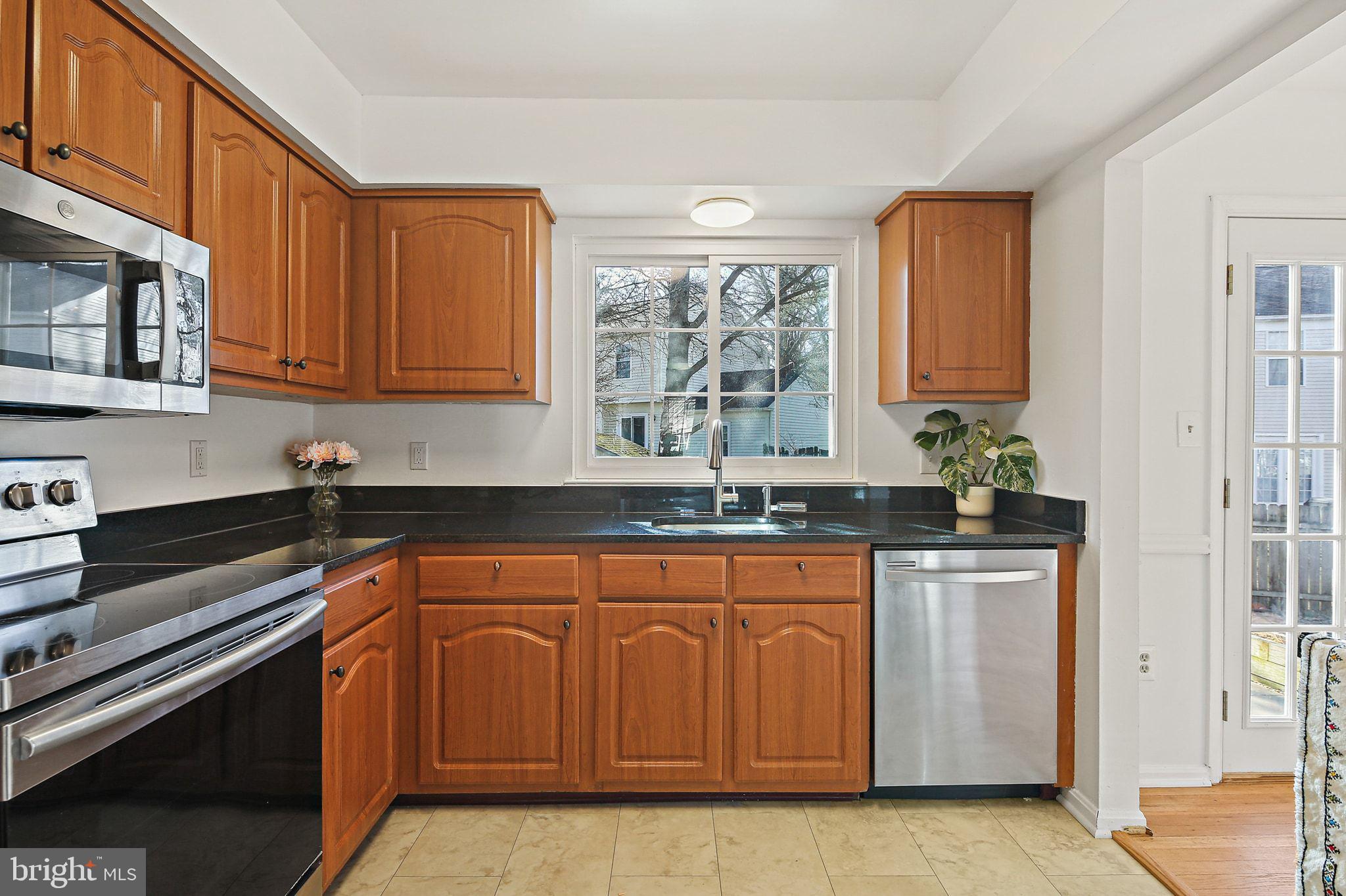 7510 Filbert Terrace Gaithersburg, MD 20879 - Photo 15 of 40 a kitchen with stainless steel appliances granite countertop a stove a sink and a microwave