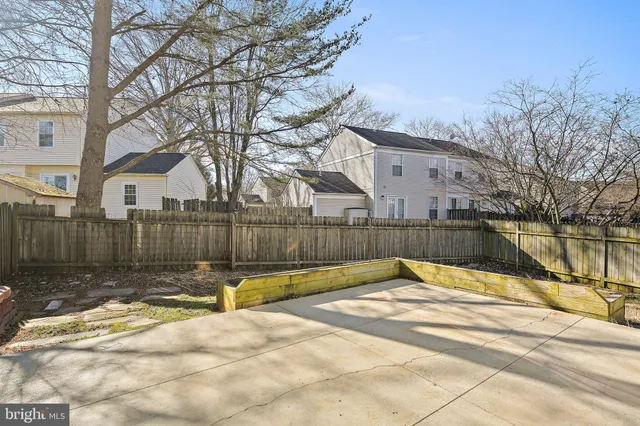 a view of backyard with wooden fence and large trees