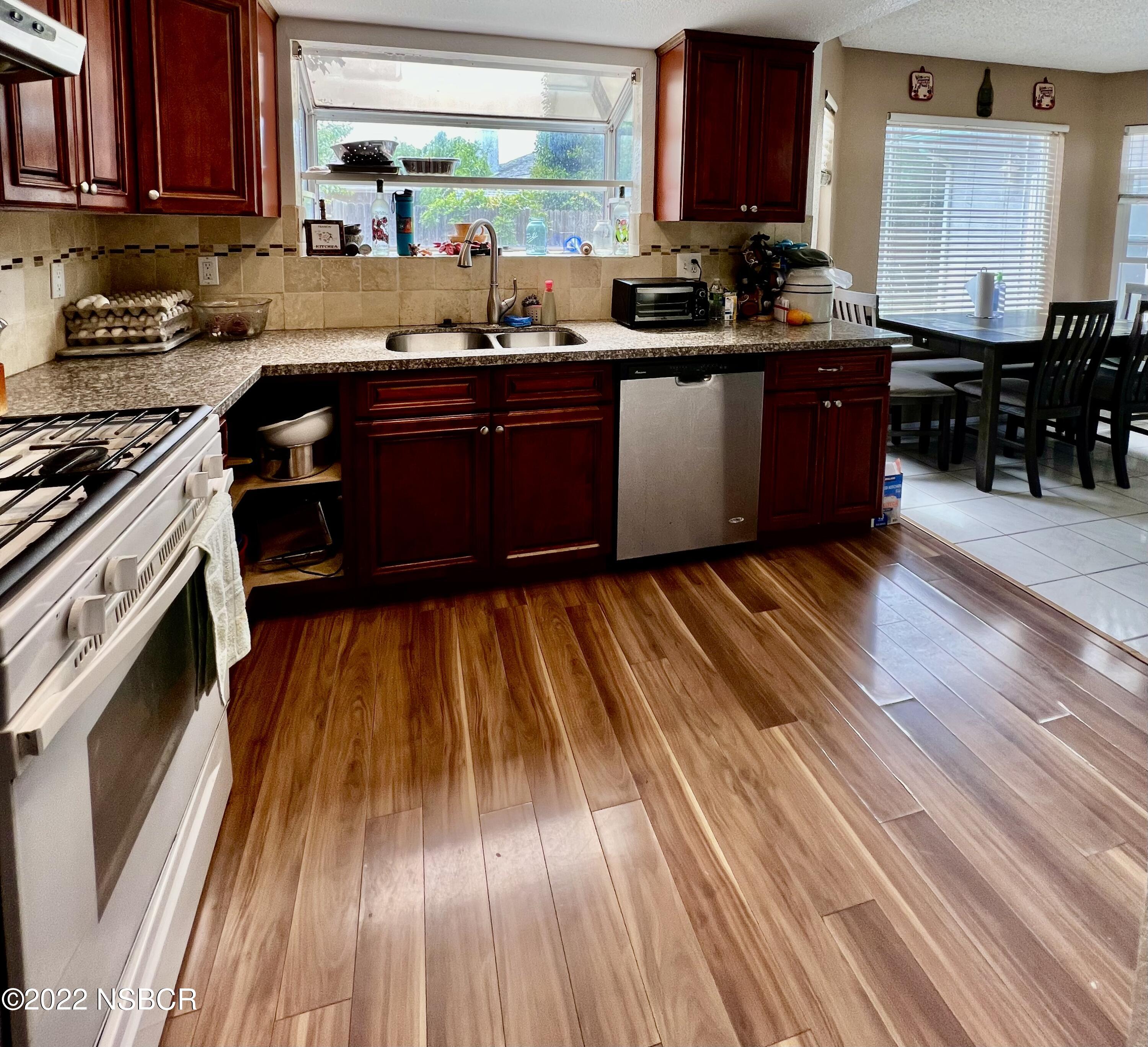 1233 Aster Lane Lompoc, CA 93436 - Photo 2 of 15 a kitchen with wooden floors and wooden cabinets