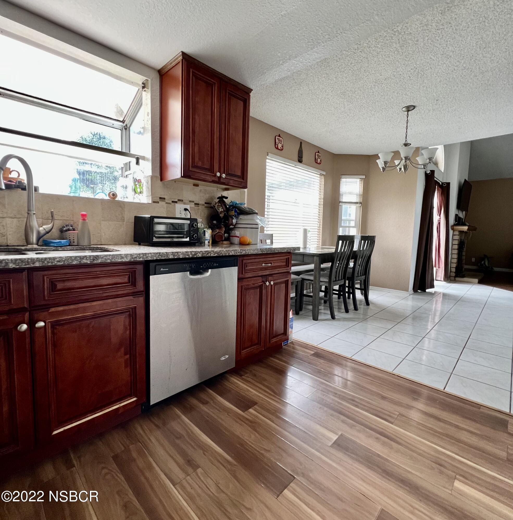 1233 Aster Lane Lompoc, CA 93436 - Photo 4 of 15 a kitchen with stainless steel appliances granite countertop wooden cabinets a dining table and chairs
