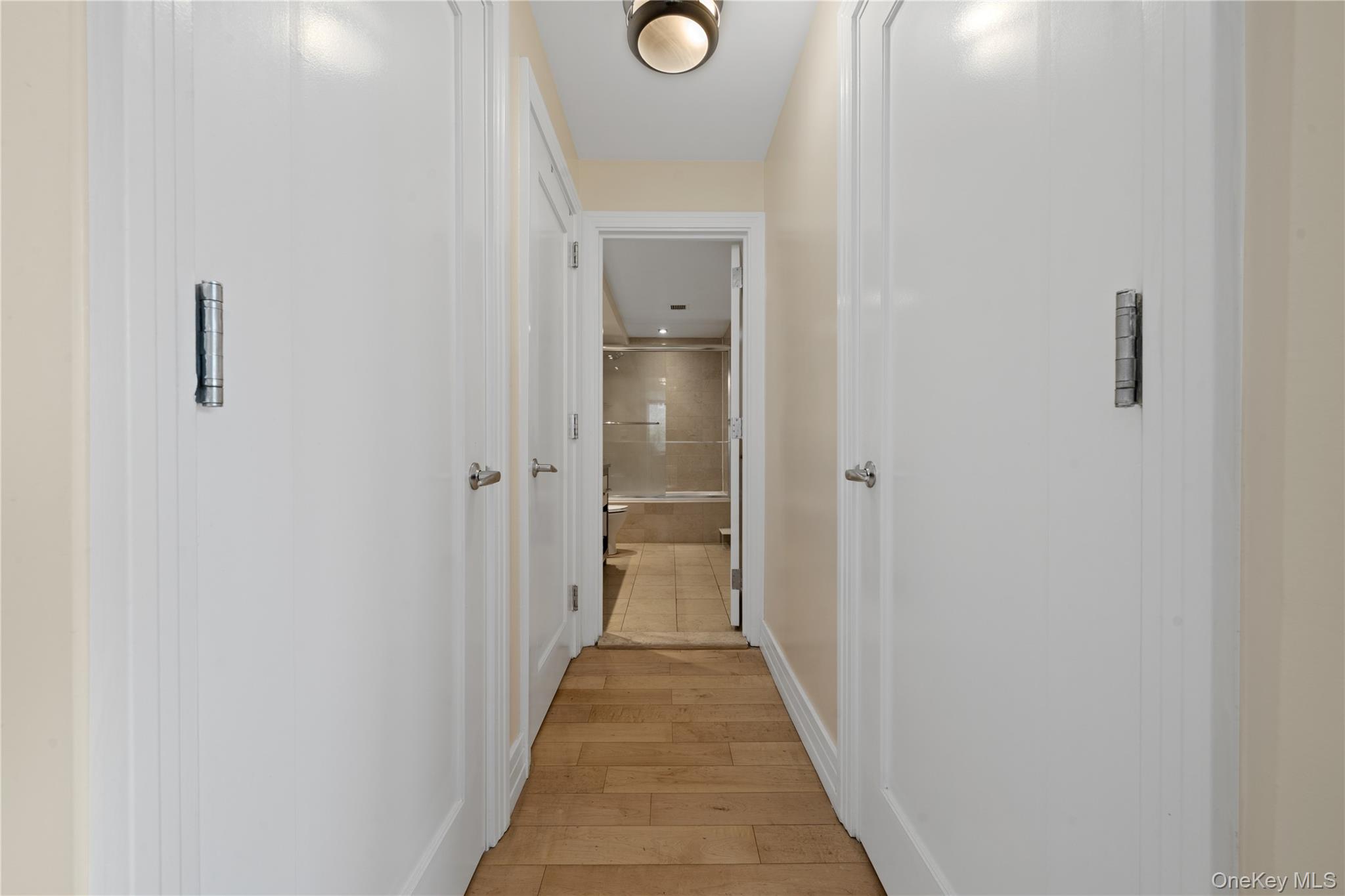 64-05 Yellowstone Boulevard, Unit PH 509 Queens, NY 11375 - Photo 11 of 28 a view of a hallway with wooden floor and a bathroom