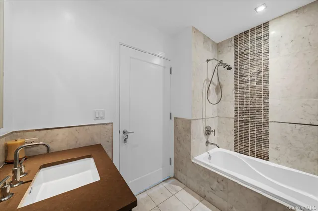 a bathroom with a tub a sink and a shower