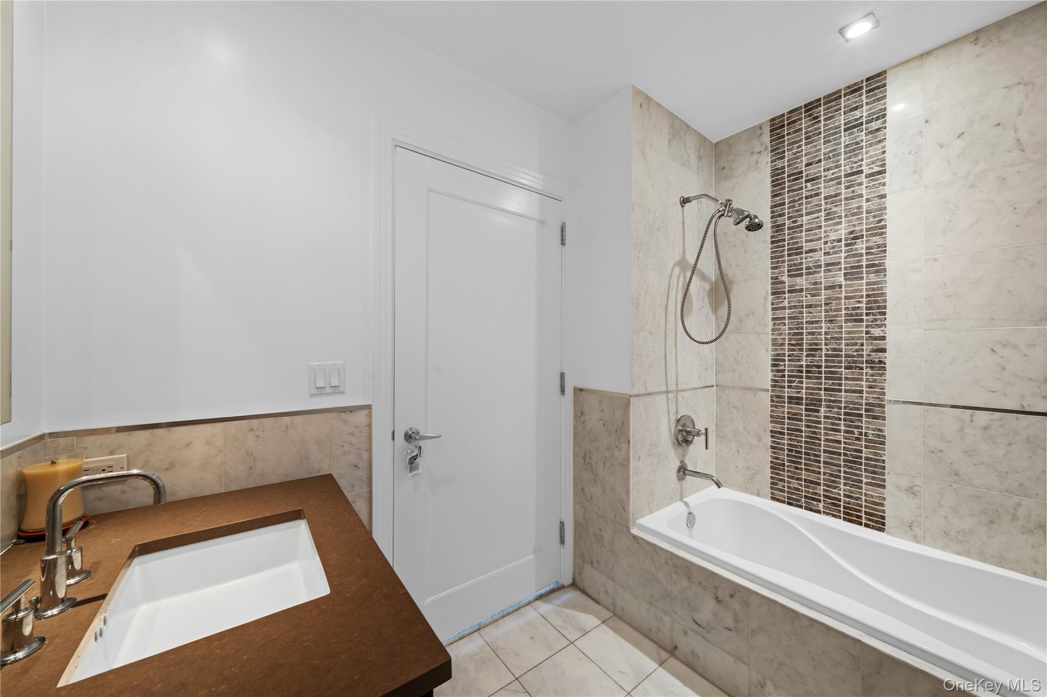 64-05 Yellowstone Boulevard, Unit PH 509 Queens, NY 11375 - Photo 13 of 28 a bathroom with a tub a sink and a shower