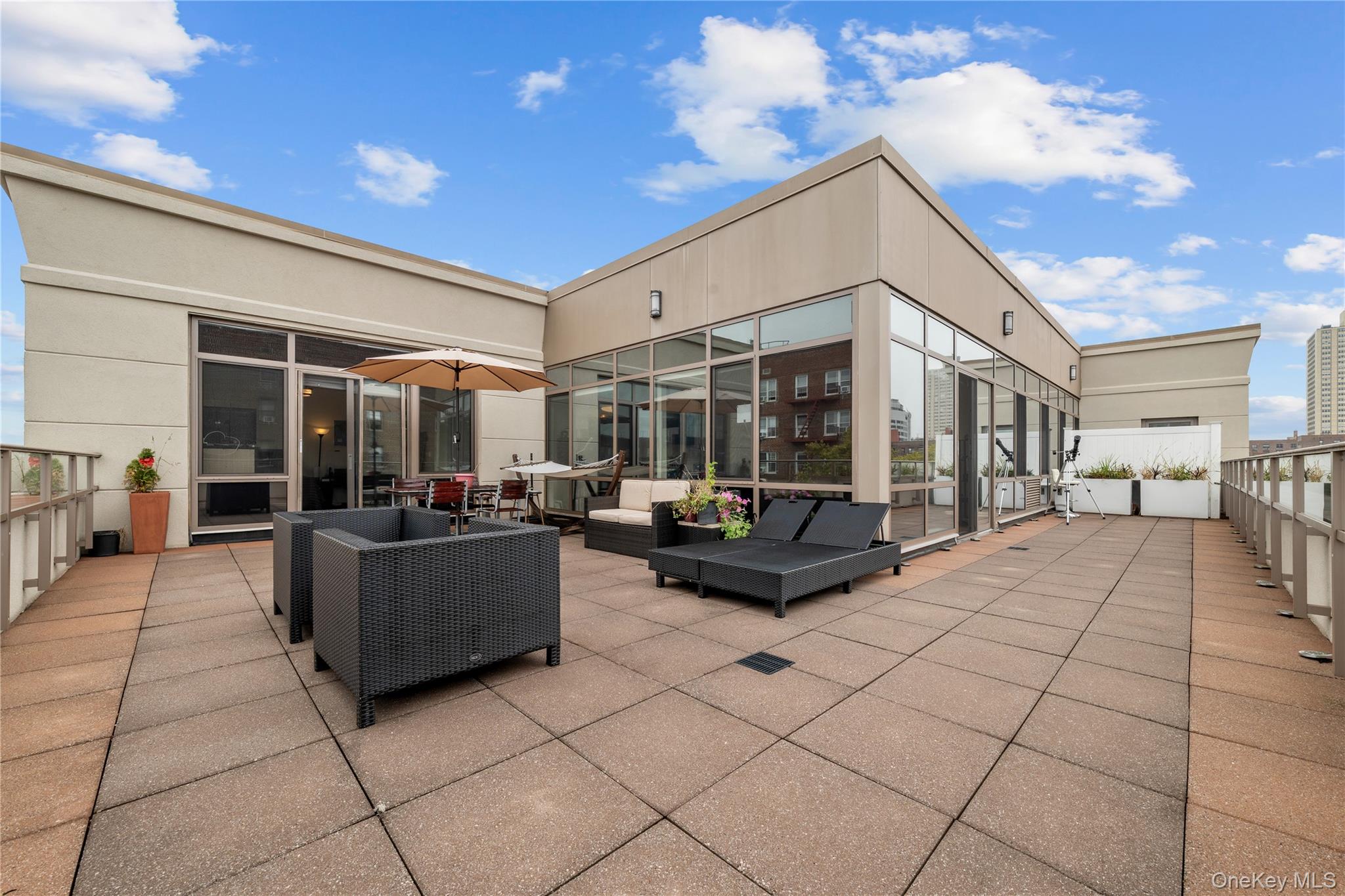 64-05 Yellowstone Boulevard, Unit PH 509 Queens, NY 11375 - Photo 16 of 28 a living room with patio furniture and a potted plant