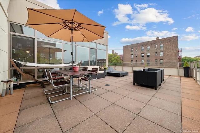 a view of a patio with dining table and chairs