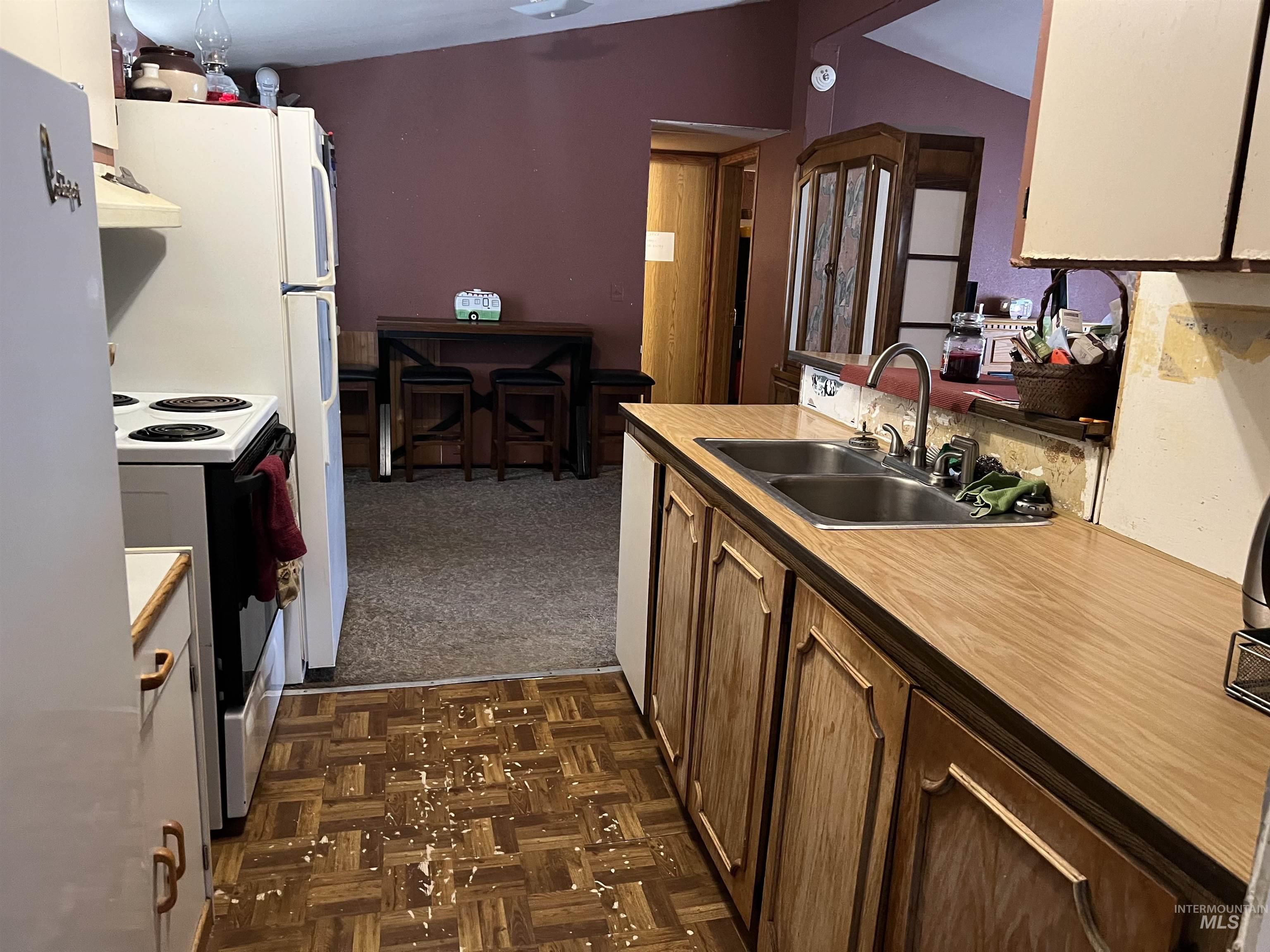 23743 Stephen Lane Parma, ID 83660 - Photo 25 of 34 Kitchen featuring white electric range, light countertops, range hood, parquet floors, and lofted ceiling
