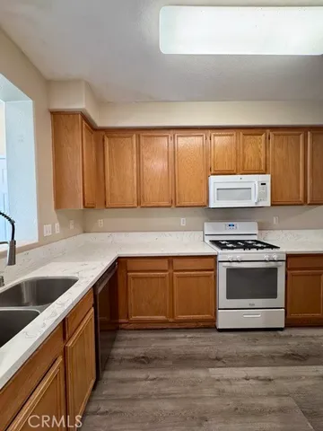 a view of a hallway with wooden floor and cabinets