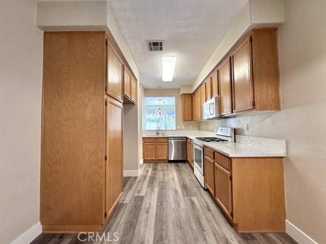 30455 Buccaneer Bay, Unit A Murrieta, CA 92563 - Photo 16 of 43 a kitchen with stainless steel appliances granite countertop a stove a sink and a refrigerator