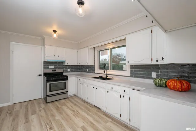 a kitchen with granite countertop a stove a sink and a refrigerator