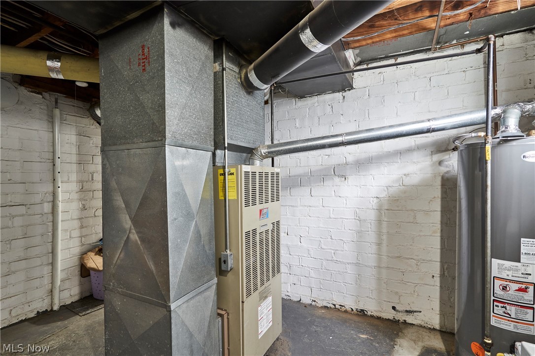 136 Smith Avenue Northwest Canton, OH 44708 - Photo 14 of 19 Utility area featuring a furnace, water heater, exposed ductwork, and white painted brick walls