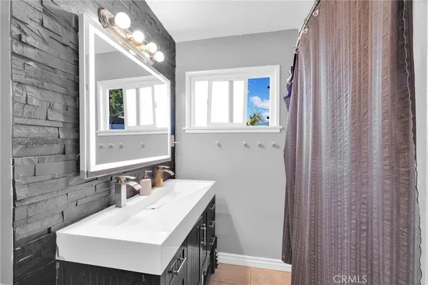 a bathroom with a sink a mirror and a window