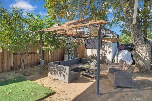 a view of a patio with table and chairs with wooden fence and plants
