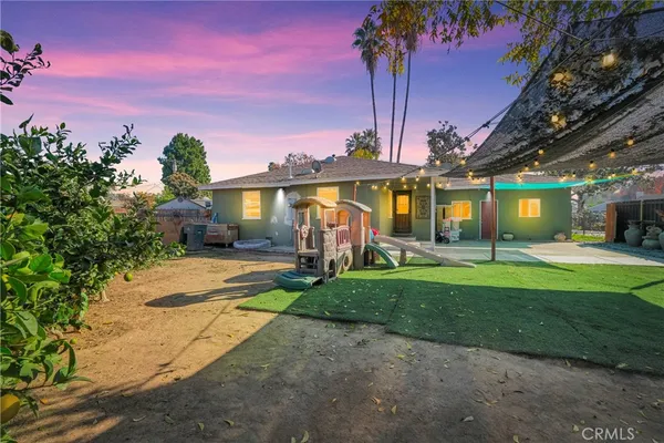 a view of a house with palm trees and a big yard
