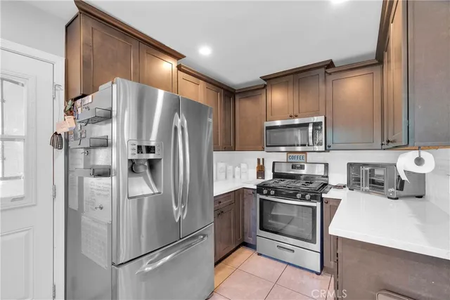 a kitchen with stainless steel appliances a refrigerator stove and microwave