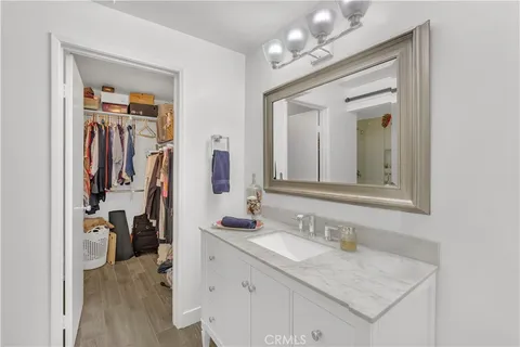 a en suite bathroom with a granite countertop sink and a mirror