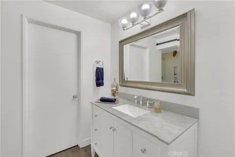 a bathroom with a granite countertop sink and a mirror