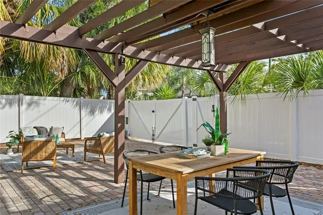 a view of a backyard with table and chairs under an umbrella with a small yard