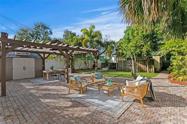 a view of a chairs and table in backyard of a house
