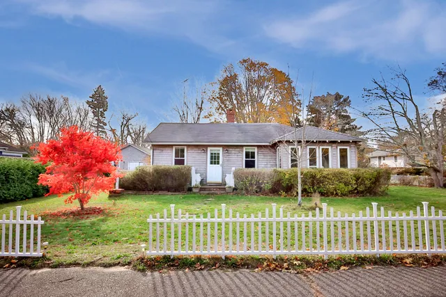a front view of a house with a garden and plants