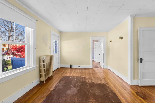 a view of a big room with wooden floor and windows
