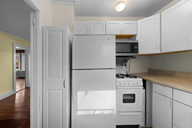 a kitchen with a stove top oven and refrigerator