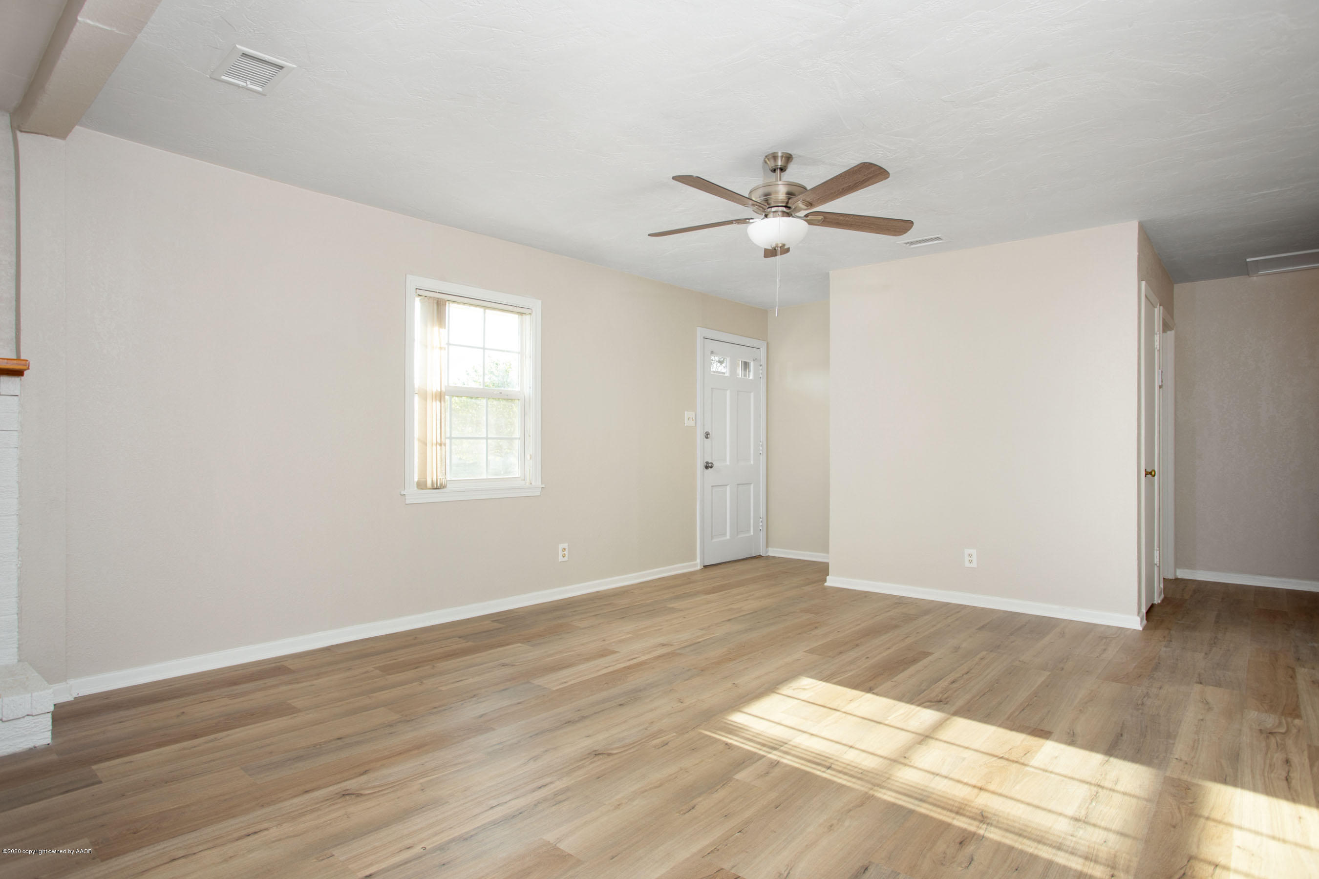 4302 South Lipscomb Street Amarillo, TX 79110 - Photo 6 of 16 a view of an empty room with wooden floor and a ceiling fan