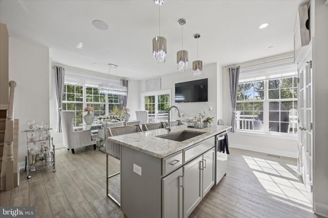 a kitchen with a sink stove and wooden floor