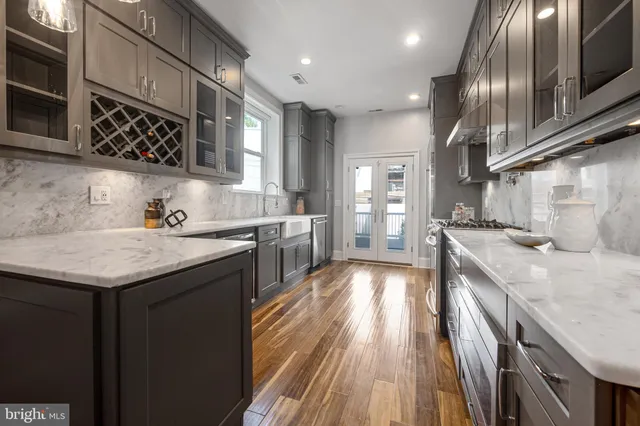a kitchen with granite countertop a sink stainless steel appliances and cabinets
