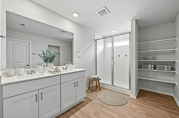 a spacious bathroom with a shower a sink and a mirror