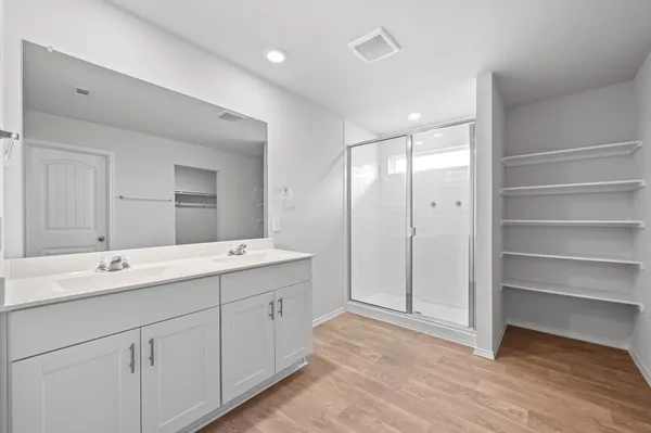 a spacious bathroom with a shower sink and mirror