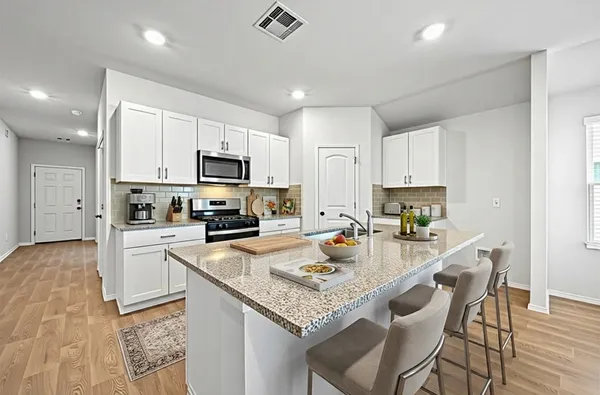 a kitchen with a sink a microwave a stove and refrigerator