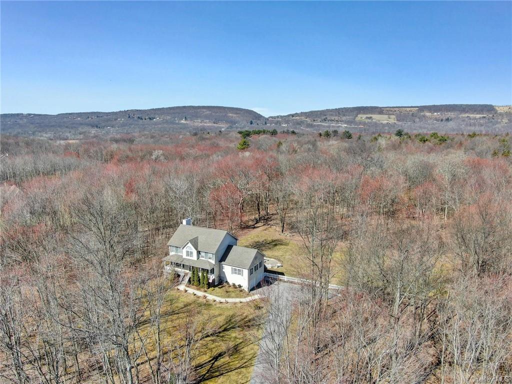 an aerial view of a house with a yard and mountain view