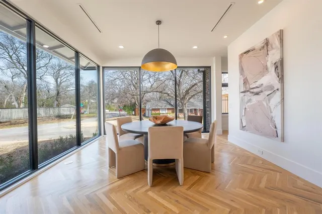 a dining room with wooden floor and a chandelier