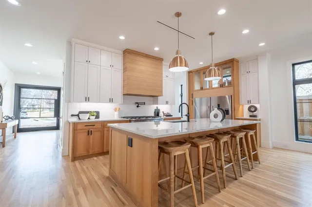 a kitchen with stainless steel appliances granite countertop a sink a stove and a wooden floors