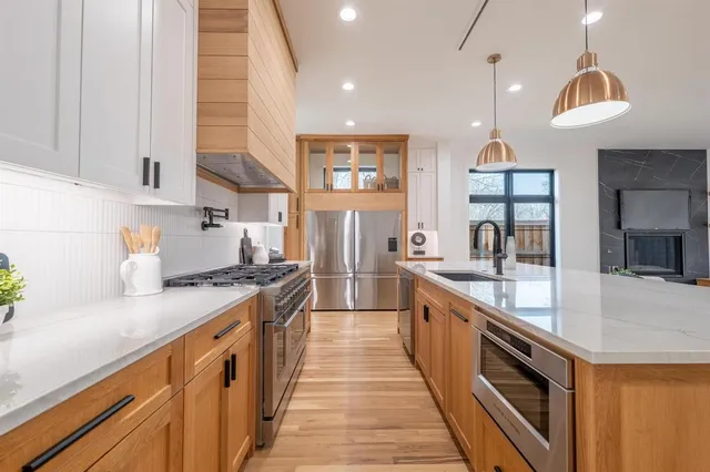 a large kitchen with stainless steel appliances granite countertop a lot of counter space and a sink