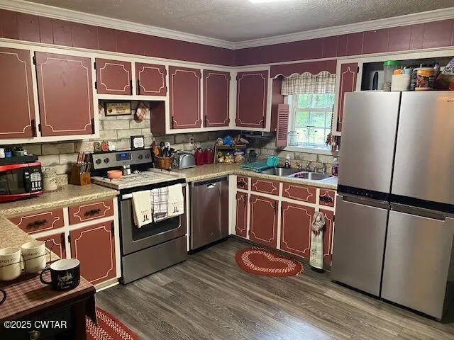 a kitchen with stainless steel appliances granite countertop a refrigerator sink and wooden cabinets