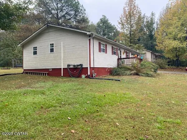 a view of backyard of house with wooden deck and seating