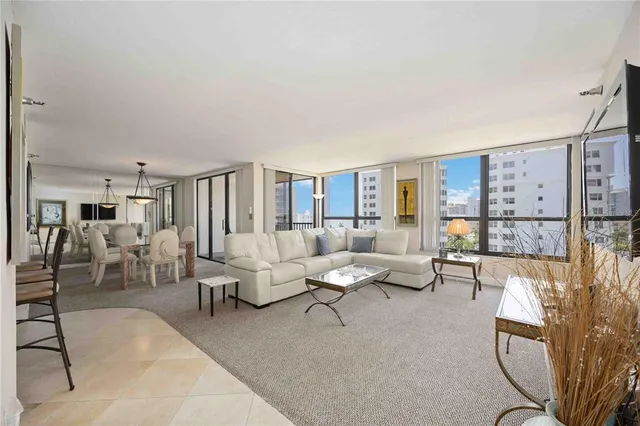 a living room with furniture large window and glass door