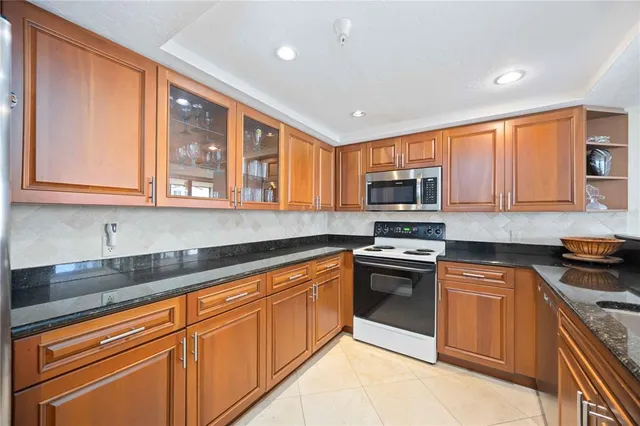 a kitchen with stainless steel appliances granite countertop a stove sink and microwave