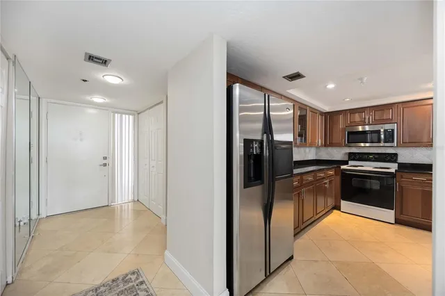 a kitchen with stainless steel appliances granite countertop a refrigerator and a stove top oven