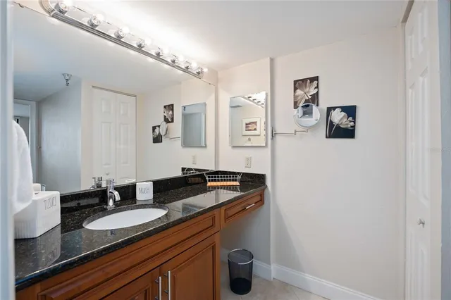 a bathroom with a granite countertop sink and a mirror