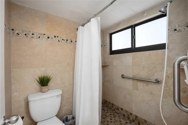 a bathroom with a toilet and a shower