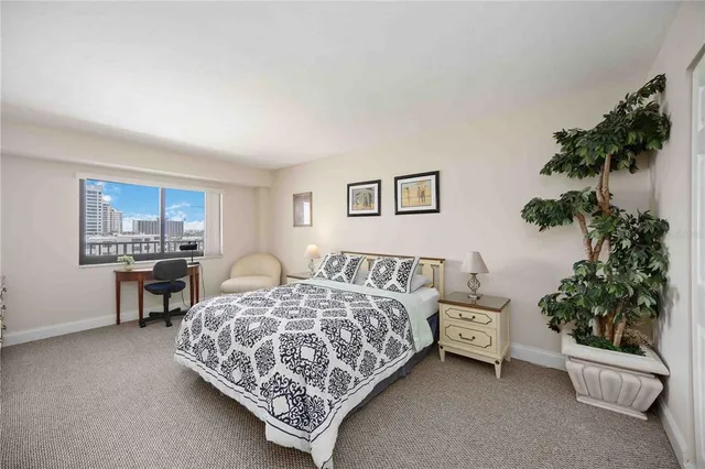 a bedroom with a bed lamp and a potted plant